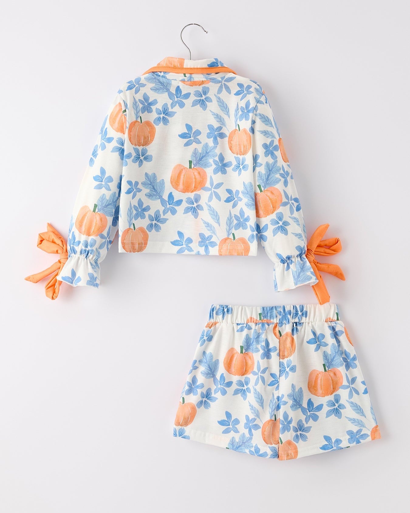 Children's outfit with pumpkin and floral pattern on a white background