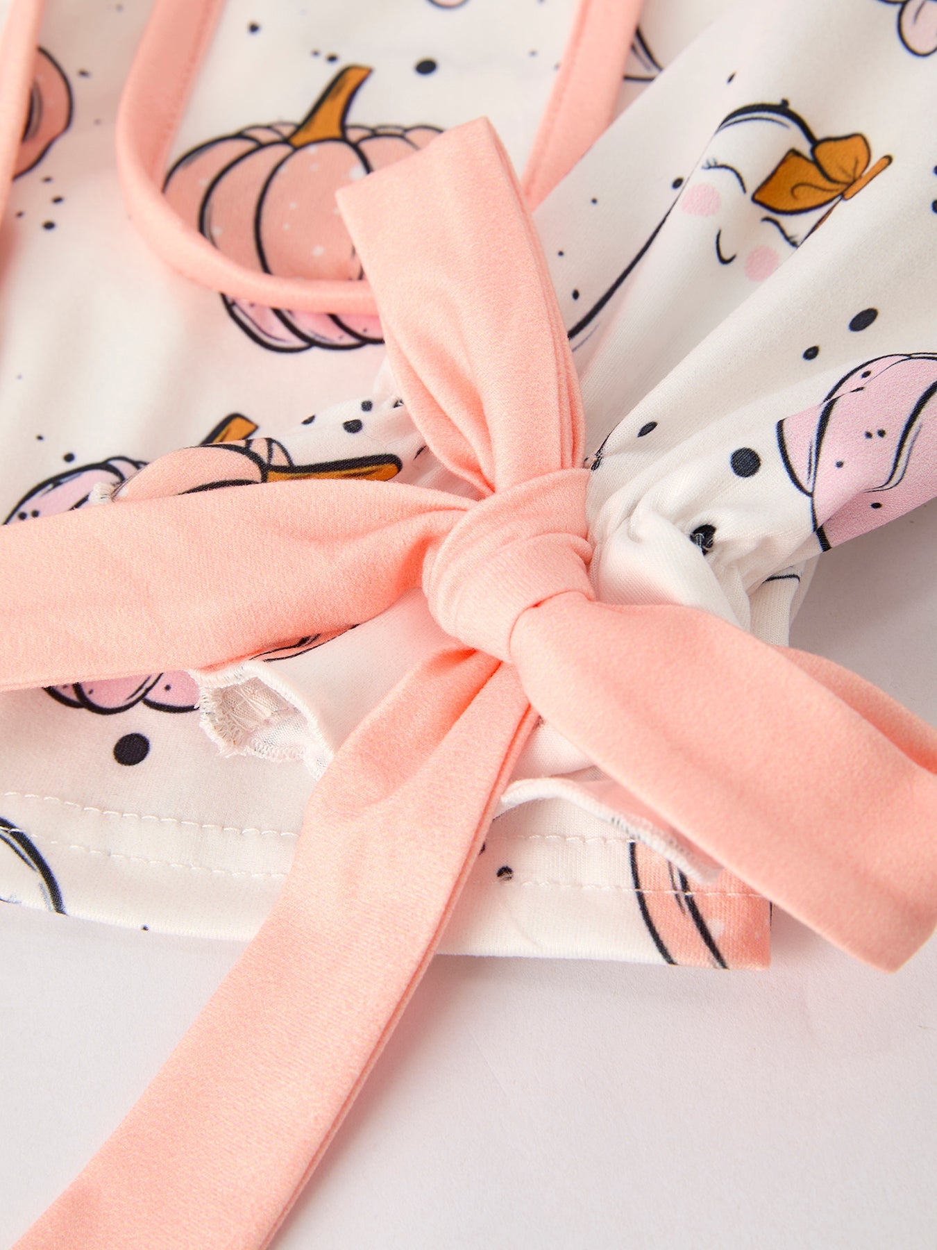 Pink bow on a white fabric with Halloween-themed design