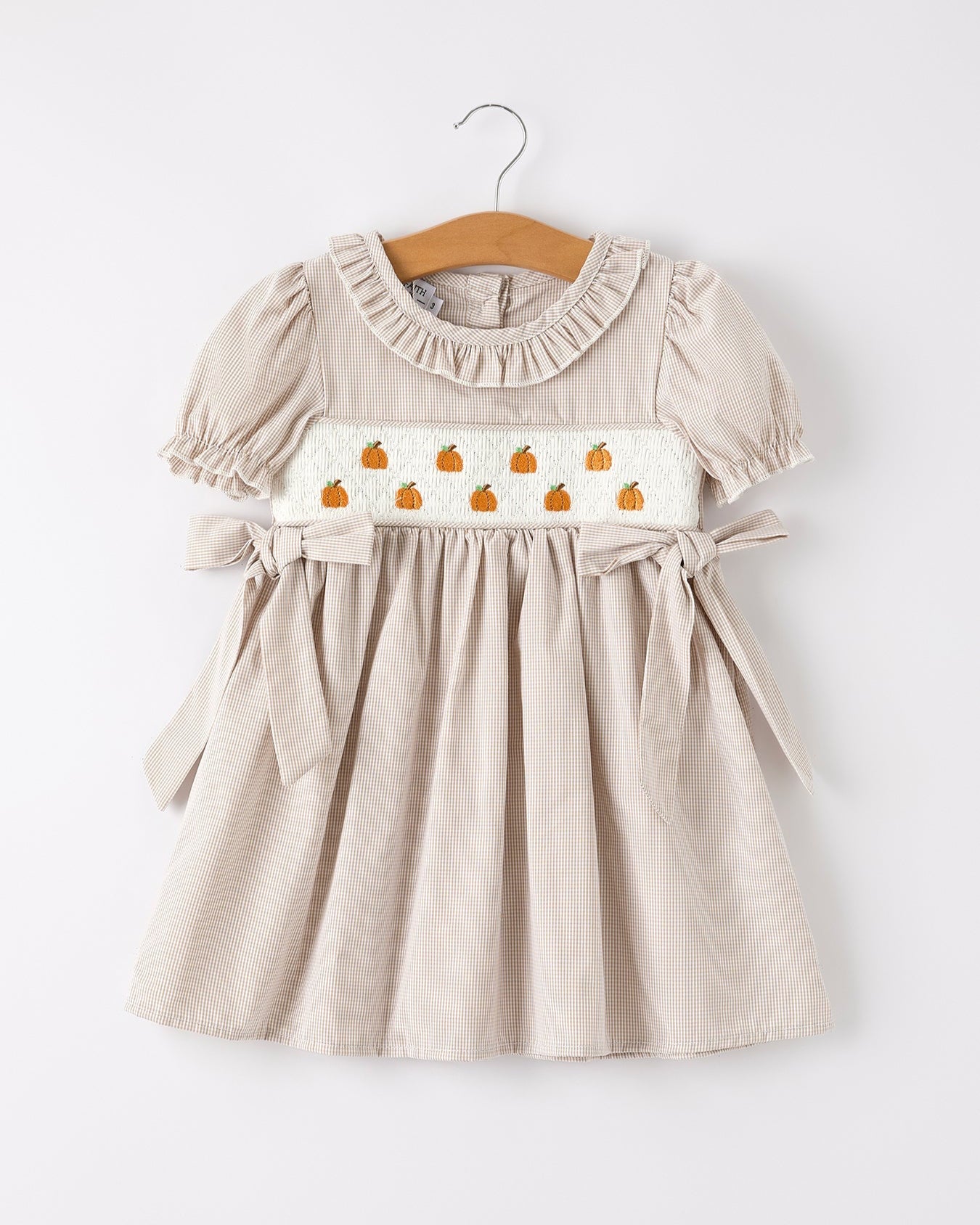 Beige dress with pumpkin pattern on a white background