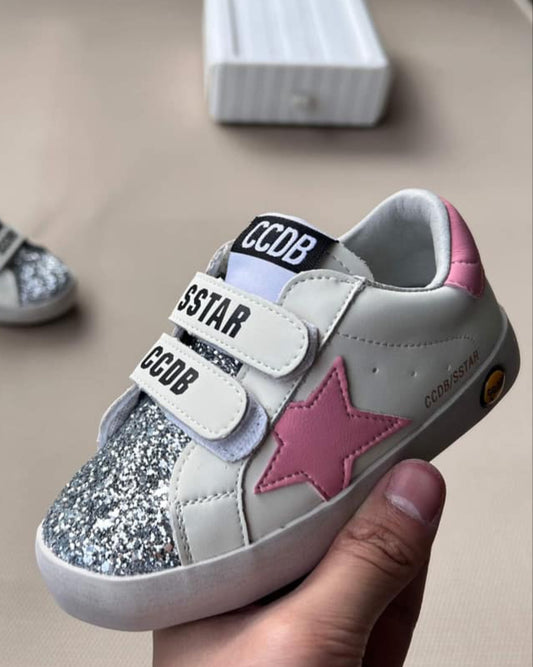 Children's shoes with pink star design and visible branding on a neutral background