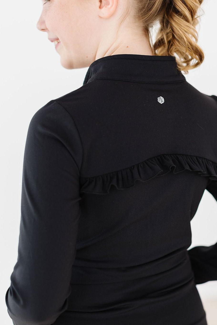 Black long-sleeve top with ruffled shoulder detail on a white background