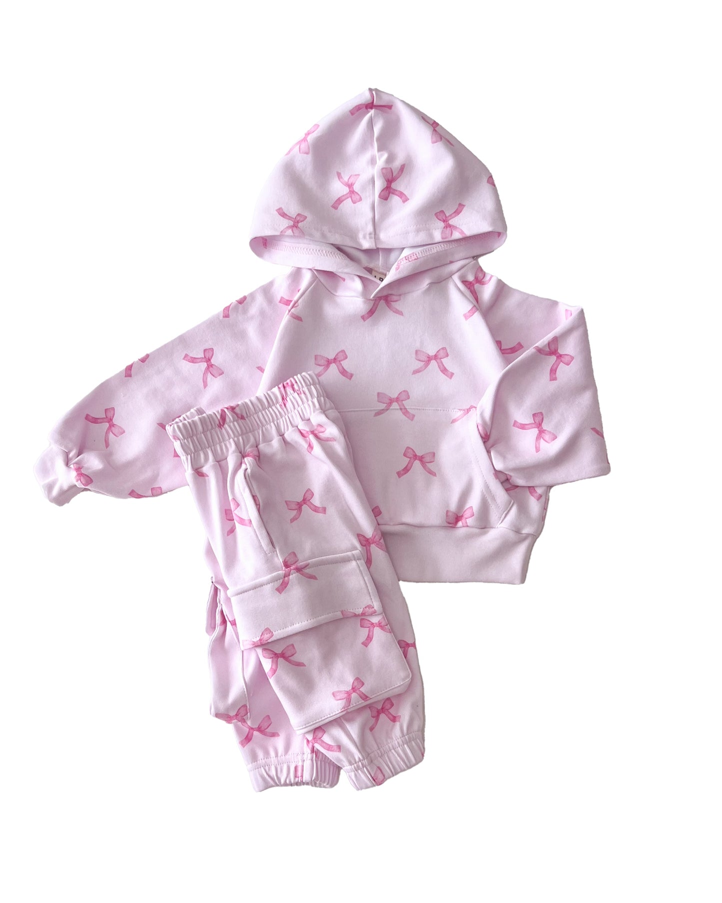 Pink hoodie and shorts set with bow pattern on a white background