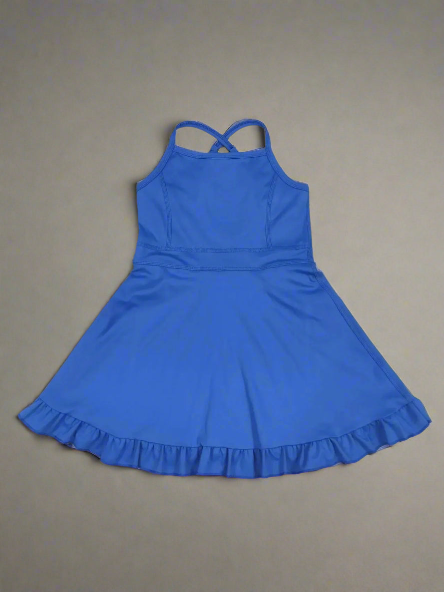 Blue dress with ruffled hem on a wooden surface