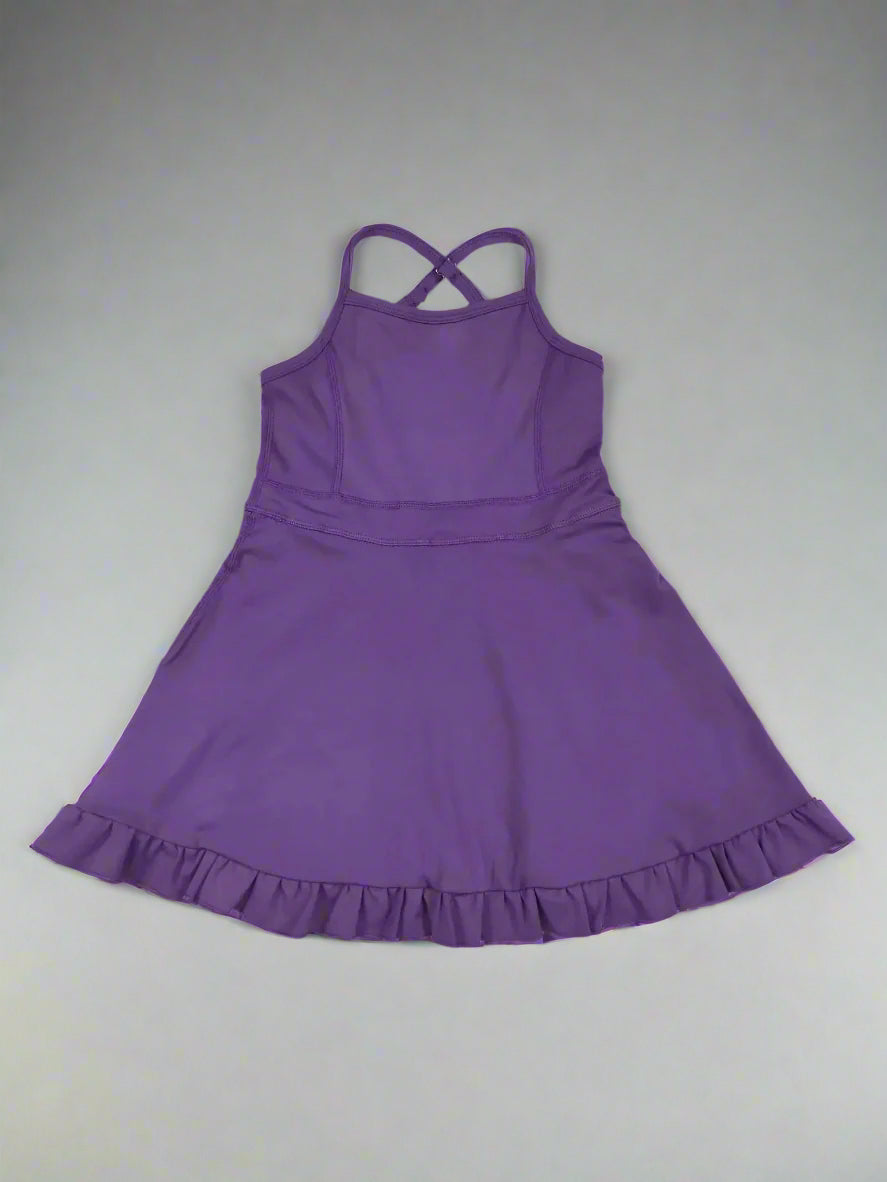 Purple dress with ruffled hem on a wooden surface