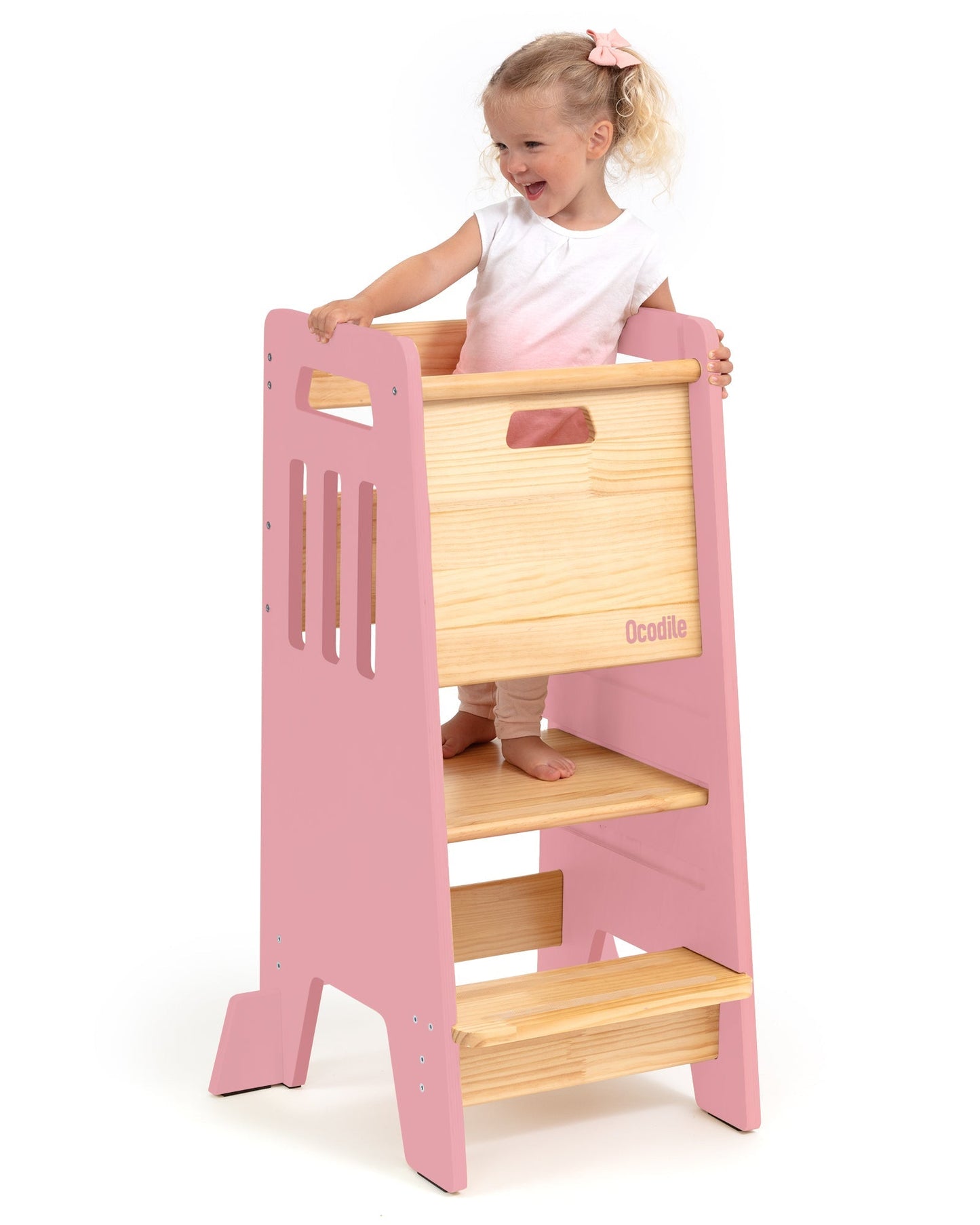 Child playing with a pink and wooden play kitchen set on a white background
