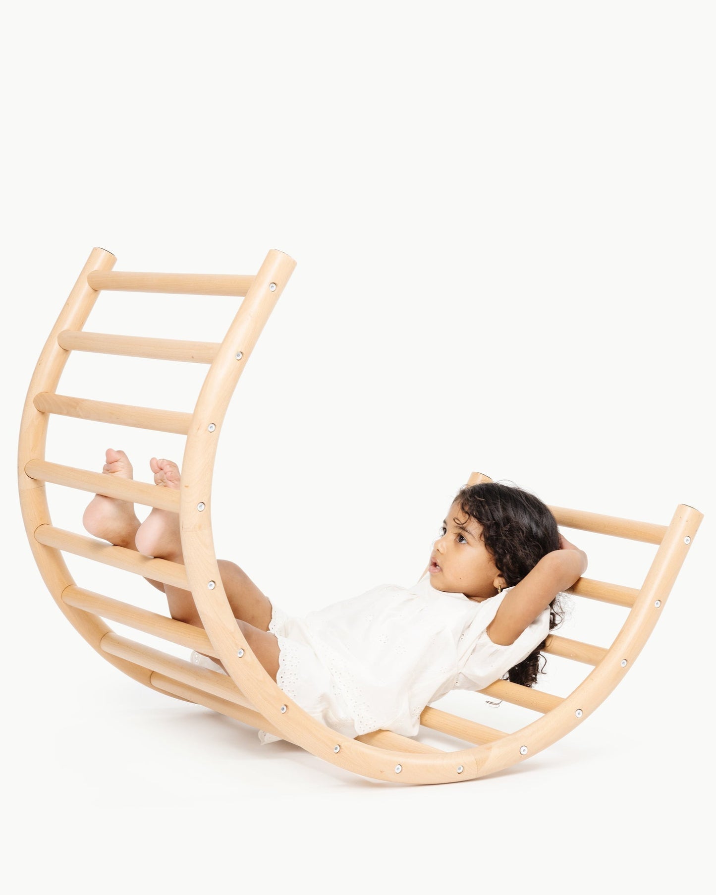 Child sitting in a wooden rocking chair on a white background