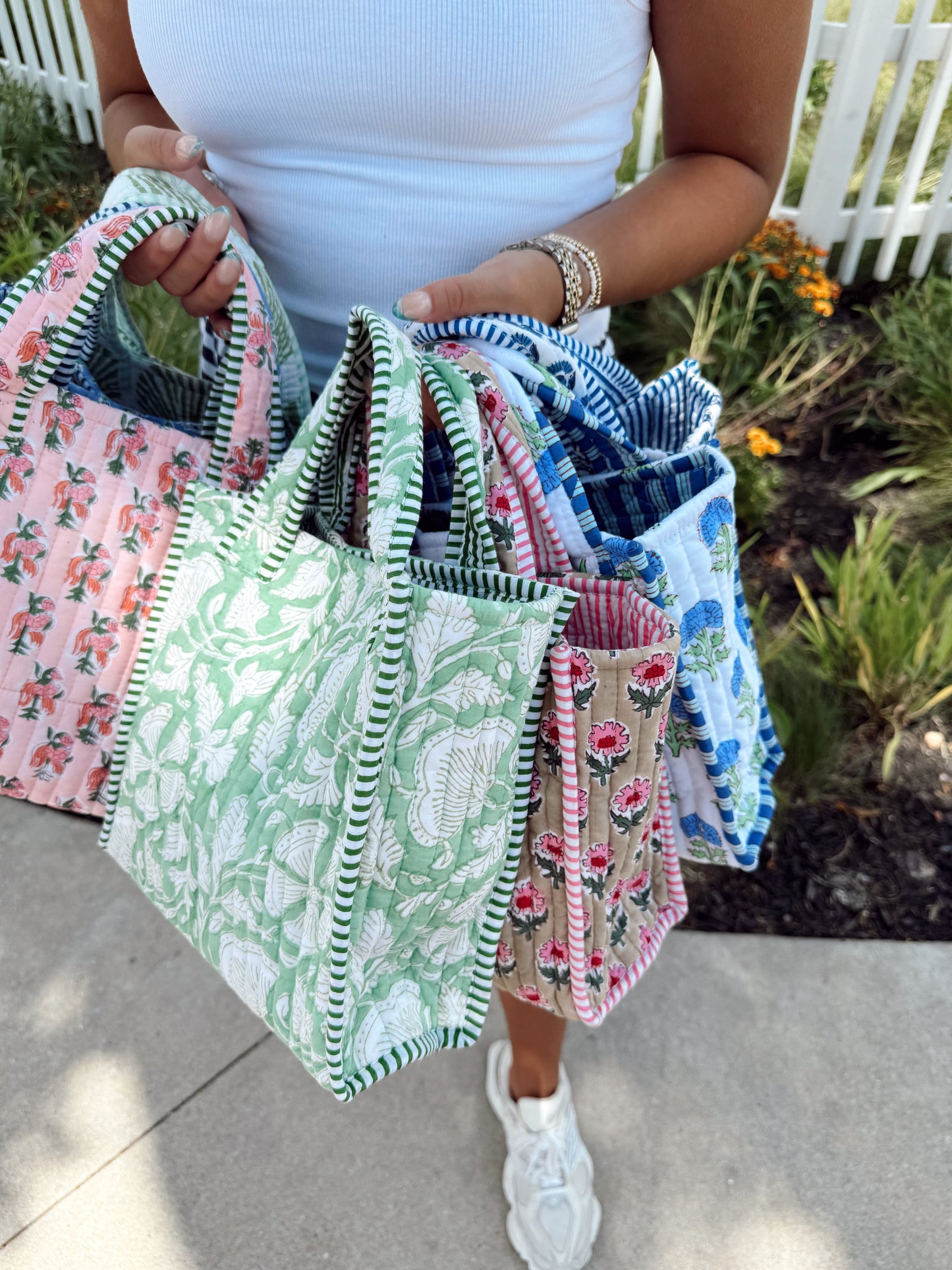 Person holding multiple patterned bags outdoors
