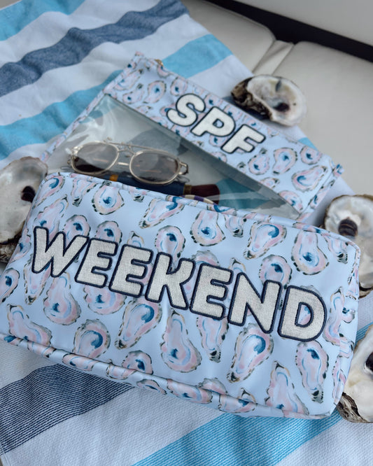 Blue pouch with 'Weekend' text on a striped fabric background