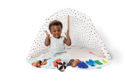 Child playing with toys on a white floor with a white canopy in the background