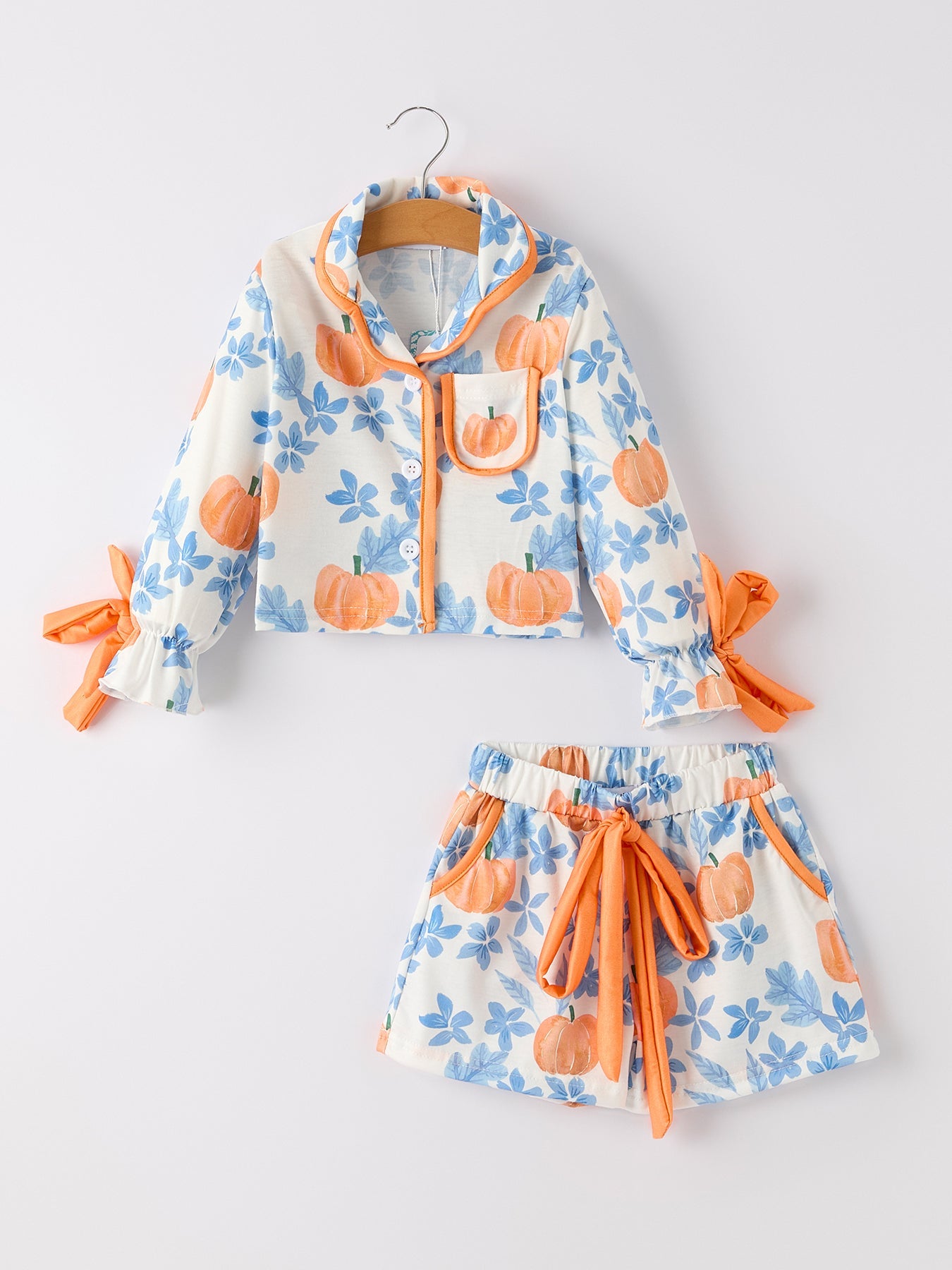 Children's outfit with floral jacket and shorts featuring pumpkins on a white background