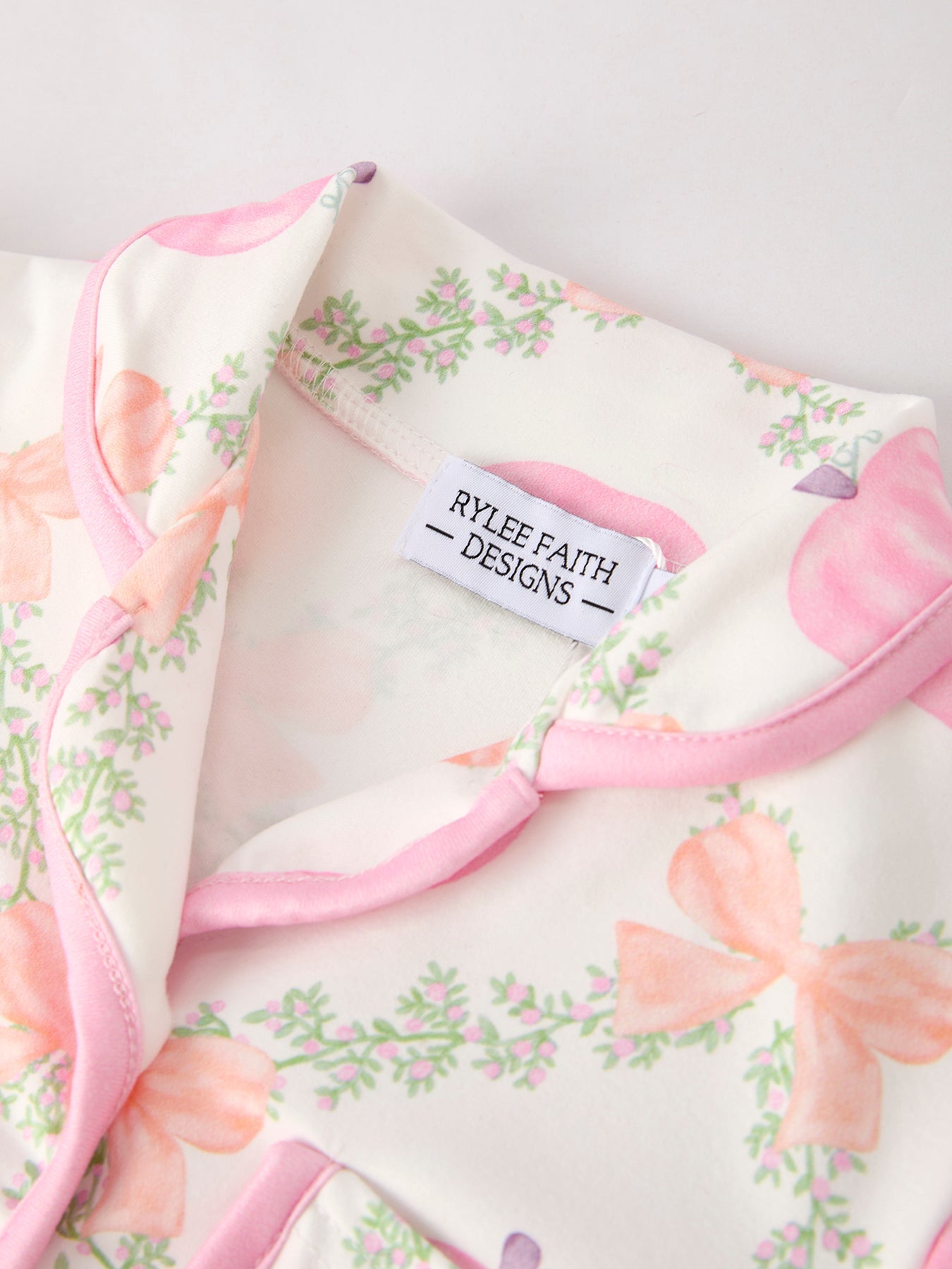 Floral blanket with pink trim and 'Rylee Faith Designs' label on a light background