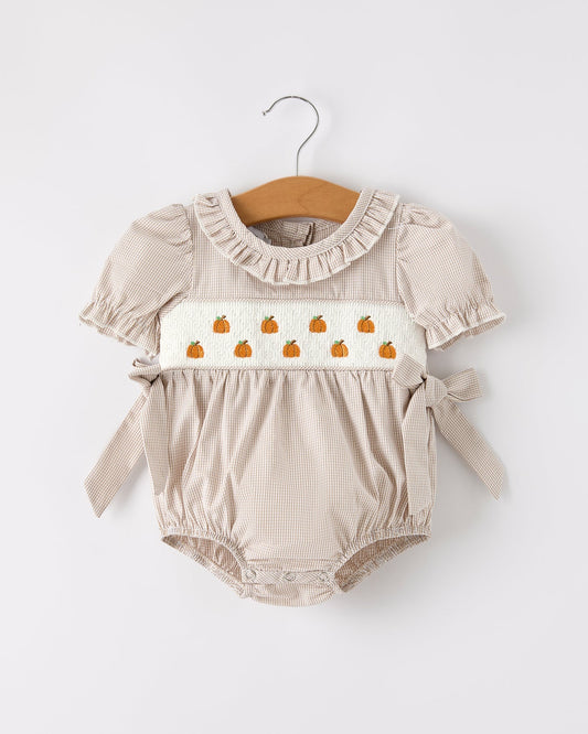 Beige baby romper with pumpkin design on a white background