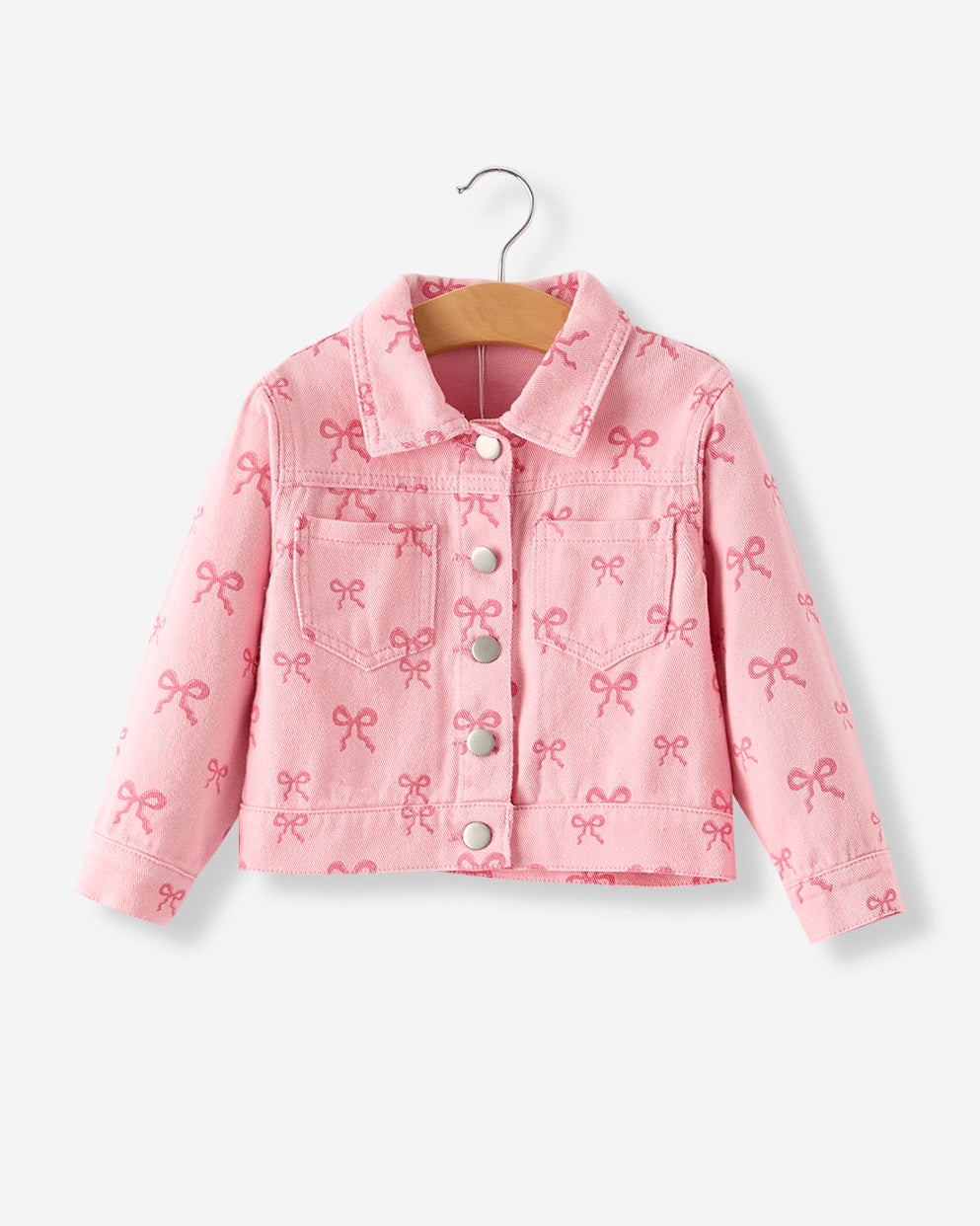 Pink denim jacket with bow pattern on a hanger against a white background