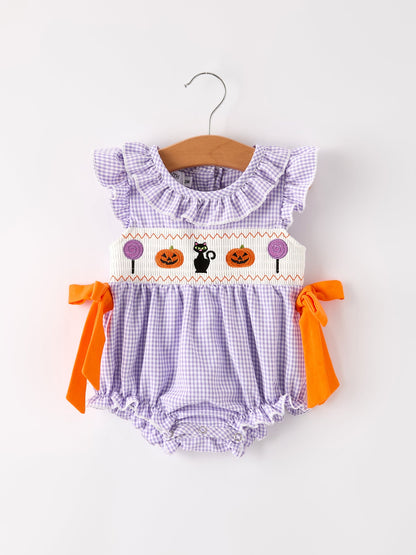 Baby romper with Halloween design on a hanger against a white background