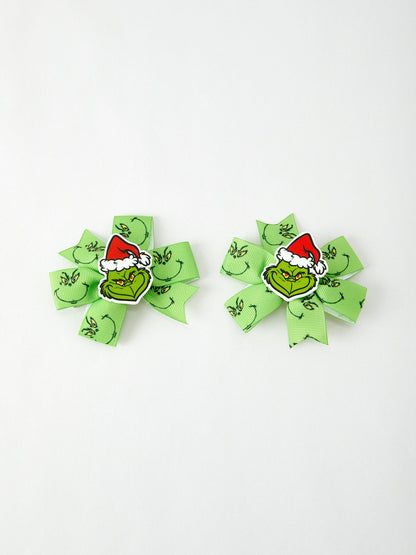 Two green hair bows with Grinch faces on a white background