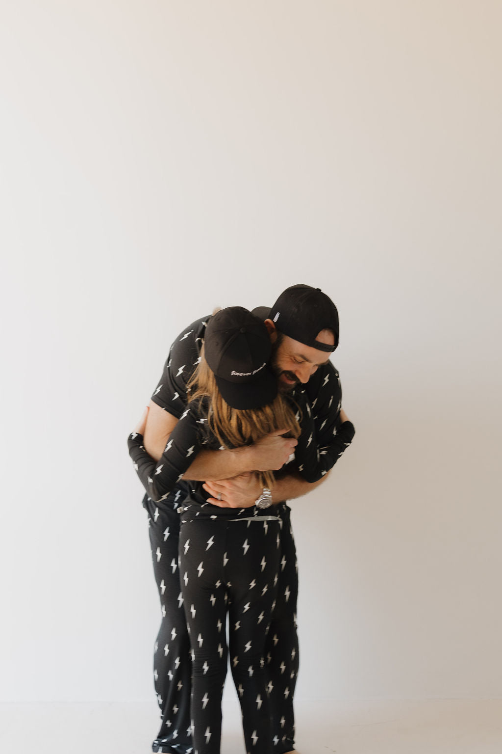 Two people hugging each other against a plain background