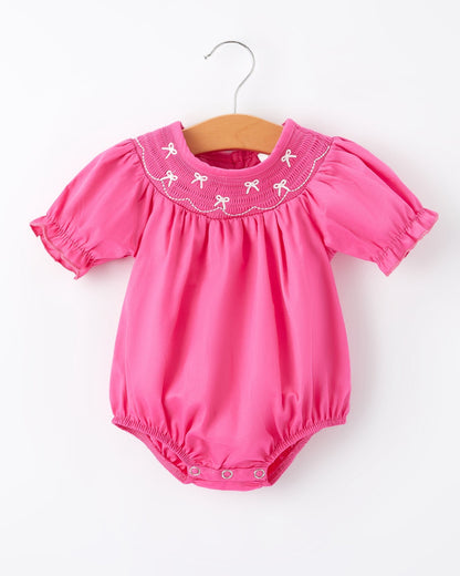 Pink baby romper with embroidered collar on a white background