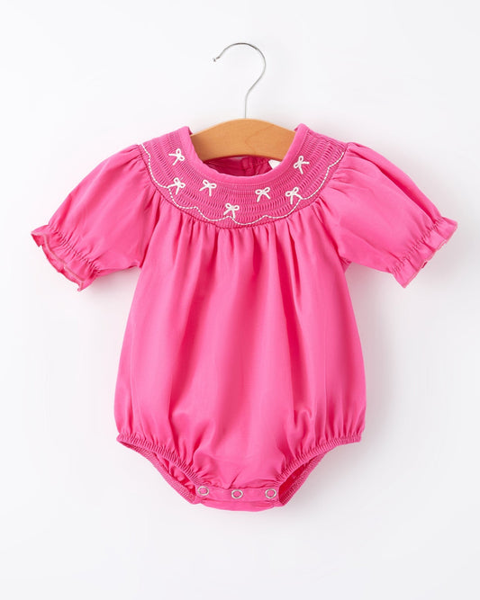 Pink baby romper with embroidered collar on a white background