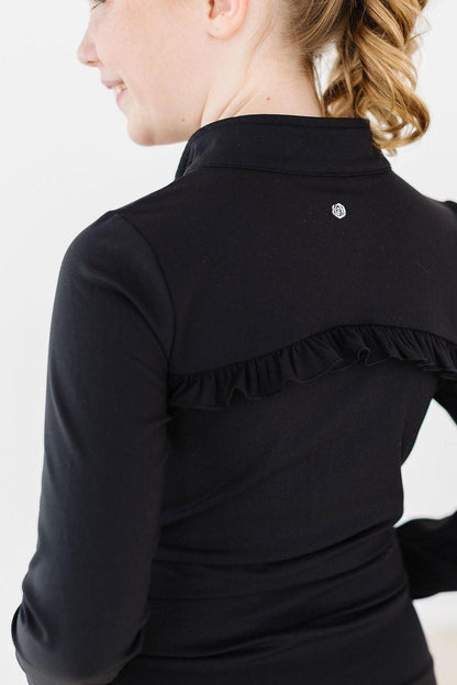 Black long-sleeve top with ruffled shoulder detail on a white background