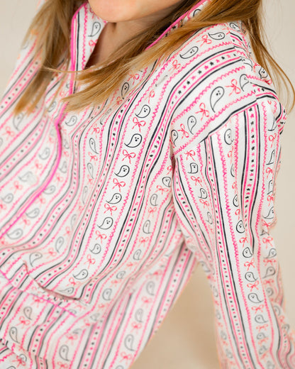 Close-up of a person wearing a pink and black patterned shirt.
