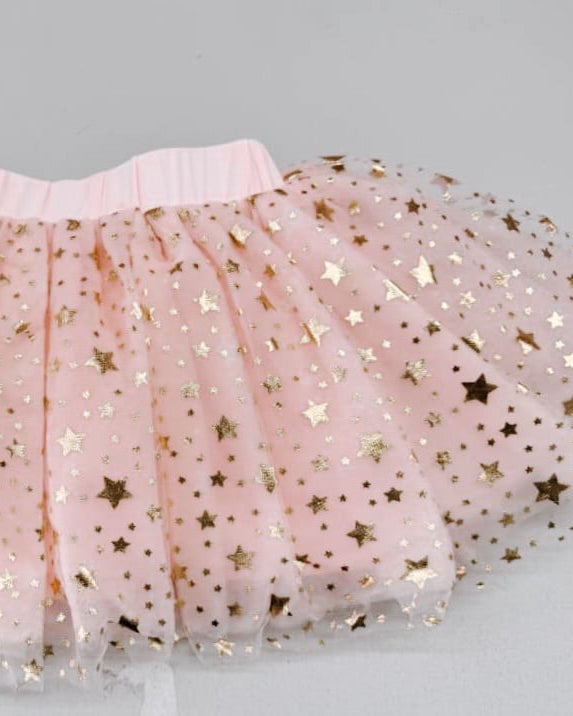 Pink tulle skirt with gold star patterns on a light gray background
