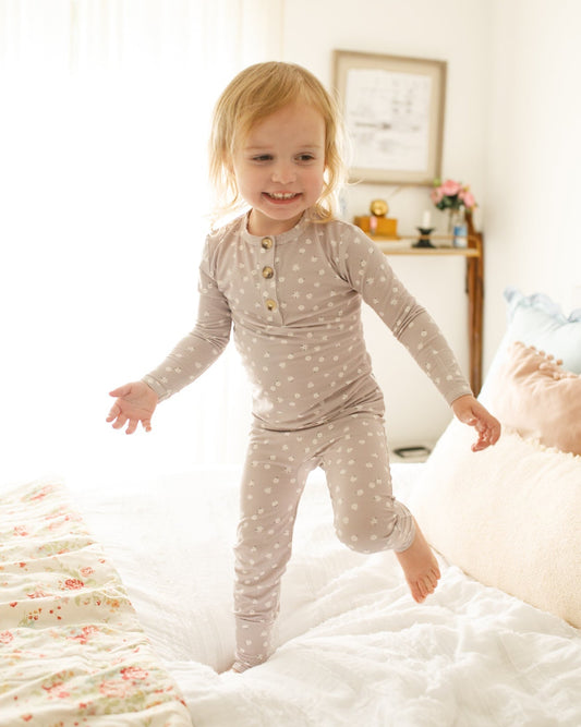 Child in pajamas jumping on a bed in a bedroom