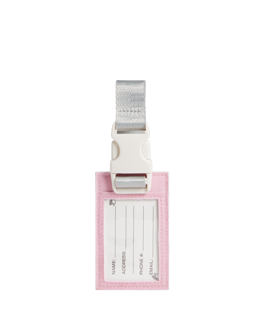Pink luggage tag with white label and silver strap on a white background