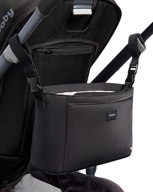 Black stroller organizer attached to a stroller on a white background