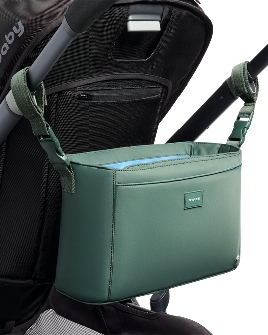Green stroller organizer attached to a UPPAbaby Vista stroller on a white background