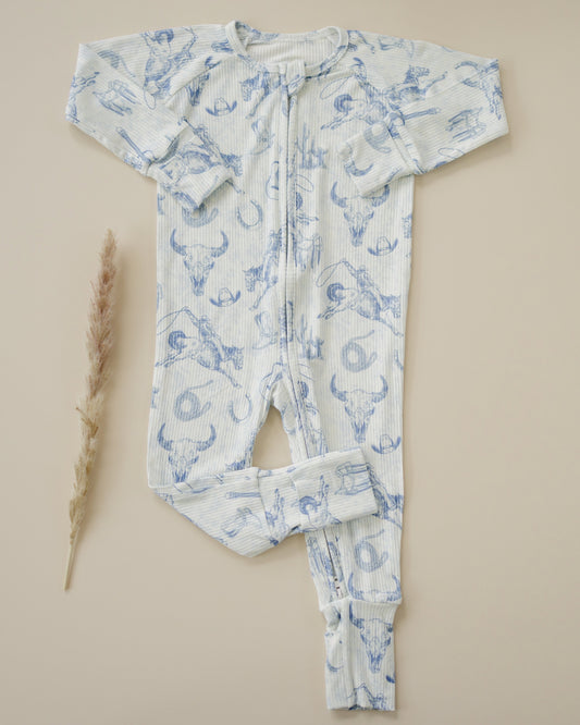 Baby onesie with blue western pattern on a beige background