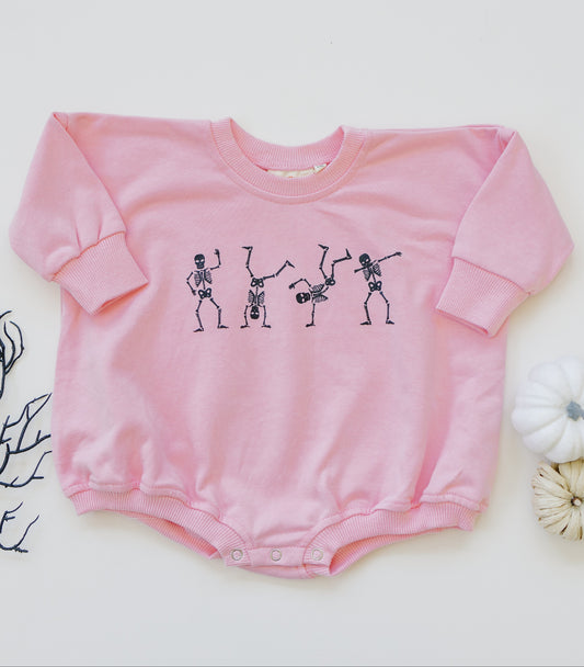 Pink baby romper with skeleton design on a white background