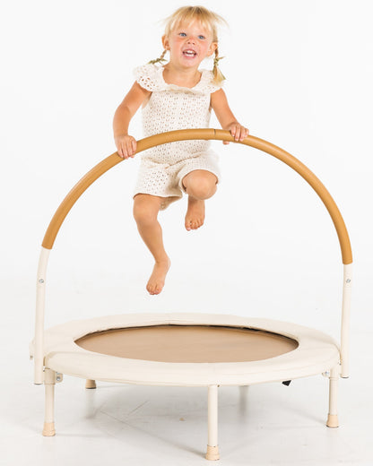Child jumping on a small trampoline with a white background