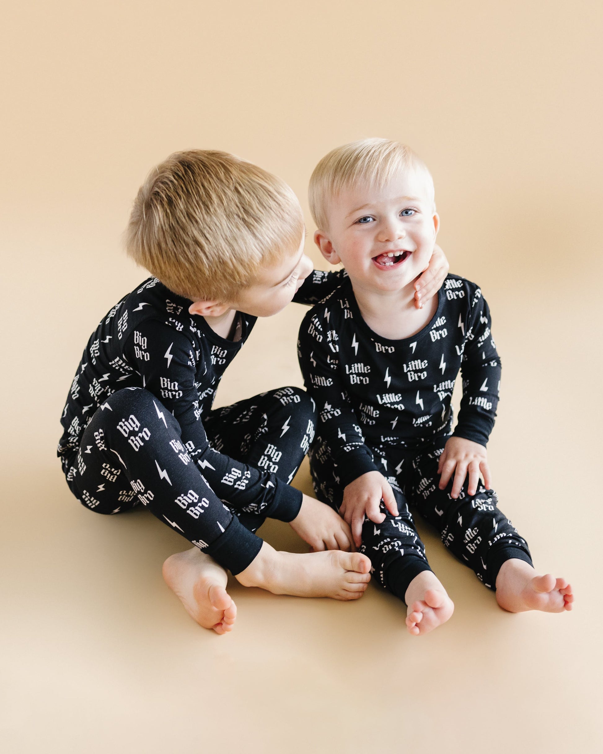 Two children wearing matching pajamas with text on a beige background