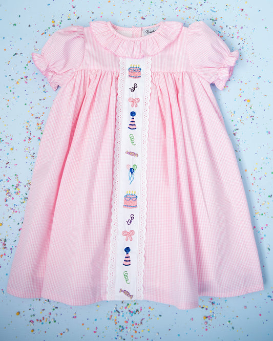 Pink dress with decorative trim on a blue background